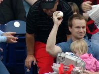 En tenant sa fille et sa nourriture dans les bras, il attrape une balle de baseball