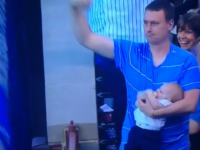 Papa attrape une balle de baseball tout en nourrissant bébé au biberon