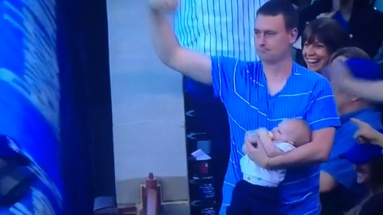 Papa attrape une balle de baseball tout en nourrissant bébé au biberon