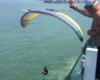 Un parapentiste attrape une bière depuis un balcon en plein vol