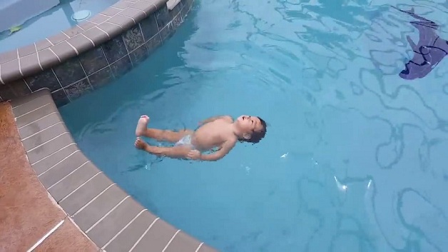 Une fillette de 12 mois nage dans une piscine sans l'aide de ses parents