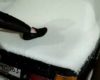 Un homme fait pipi debout sur une voiture recouverte de neige