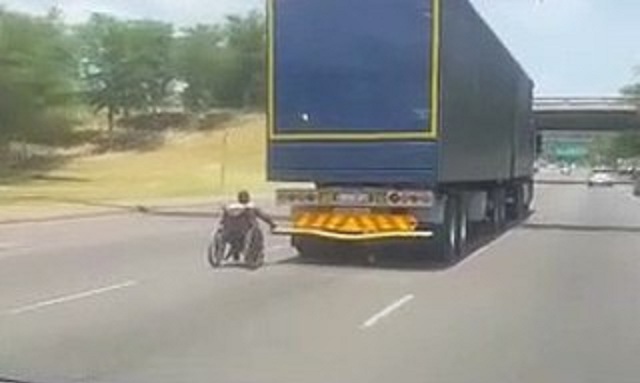 En fauteuil roulant, il s’accroche à l'arrière d'un camion qui roule sur l'autoroute
