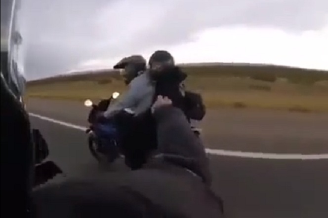 Un motard avertit un autre d'un feu dans sa moto