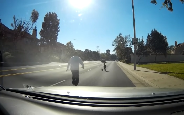 Un automobiliste va récupérer un enfant en bas âge qui joue au ballon au milieu de la route