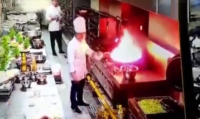 Un chef essaie d'éteindre un feu d'huile avec un torchon