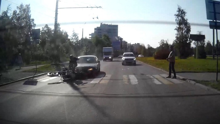 Un motard ralentit à un passage piéton lorsqu'il est percuté par une voiture