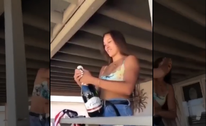 Une fille se rate en sautant le bouchon d'une bouteille de champagne