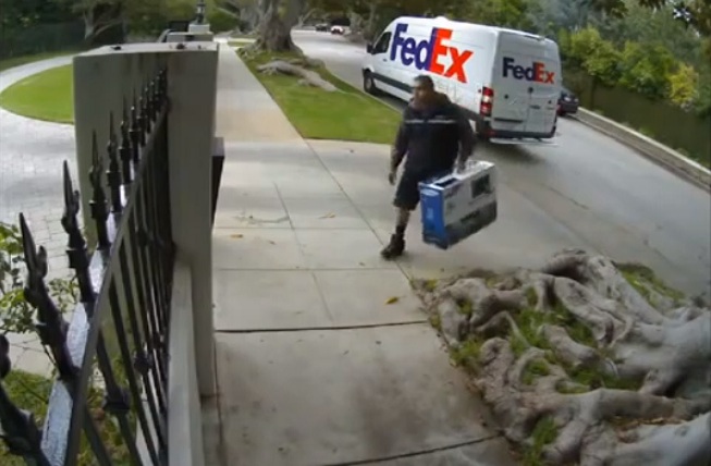 Un livreur de FedEx jette un téléviseur par-dessus une clôture
