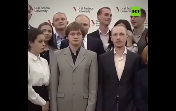 Lors d'une photo de groupe, un étudiant pose devant Poutine