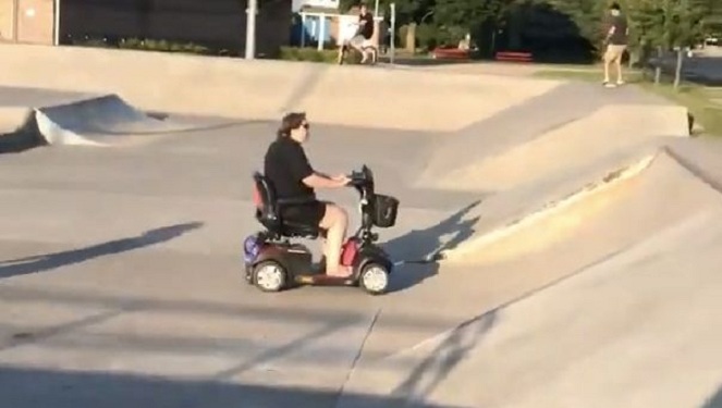Elle roule en scooter électrique d'invalide dans un Skatepark