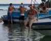 Cette femme tente d'aller à l’eau en passant par la partie avant de son bateau