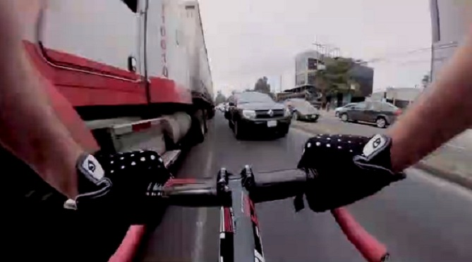 Ce cycliste prend le risque de rouler à contre-sens entre les véhicules