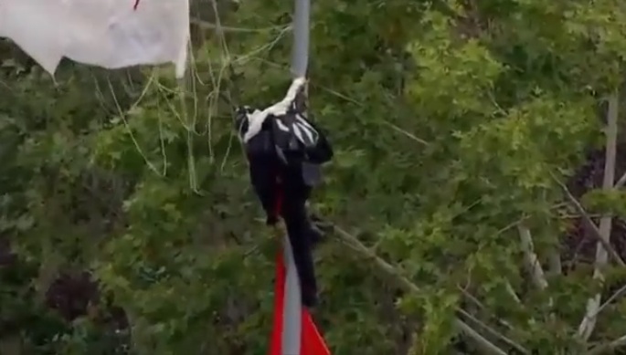 Un parachutiste se prend un lampadaire lors de sa descente avec le drapeau espagnol