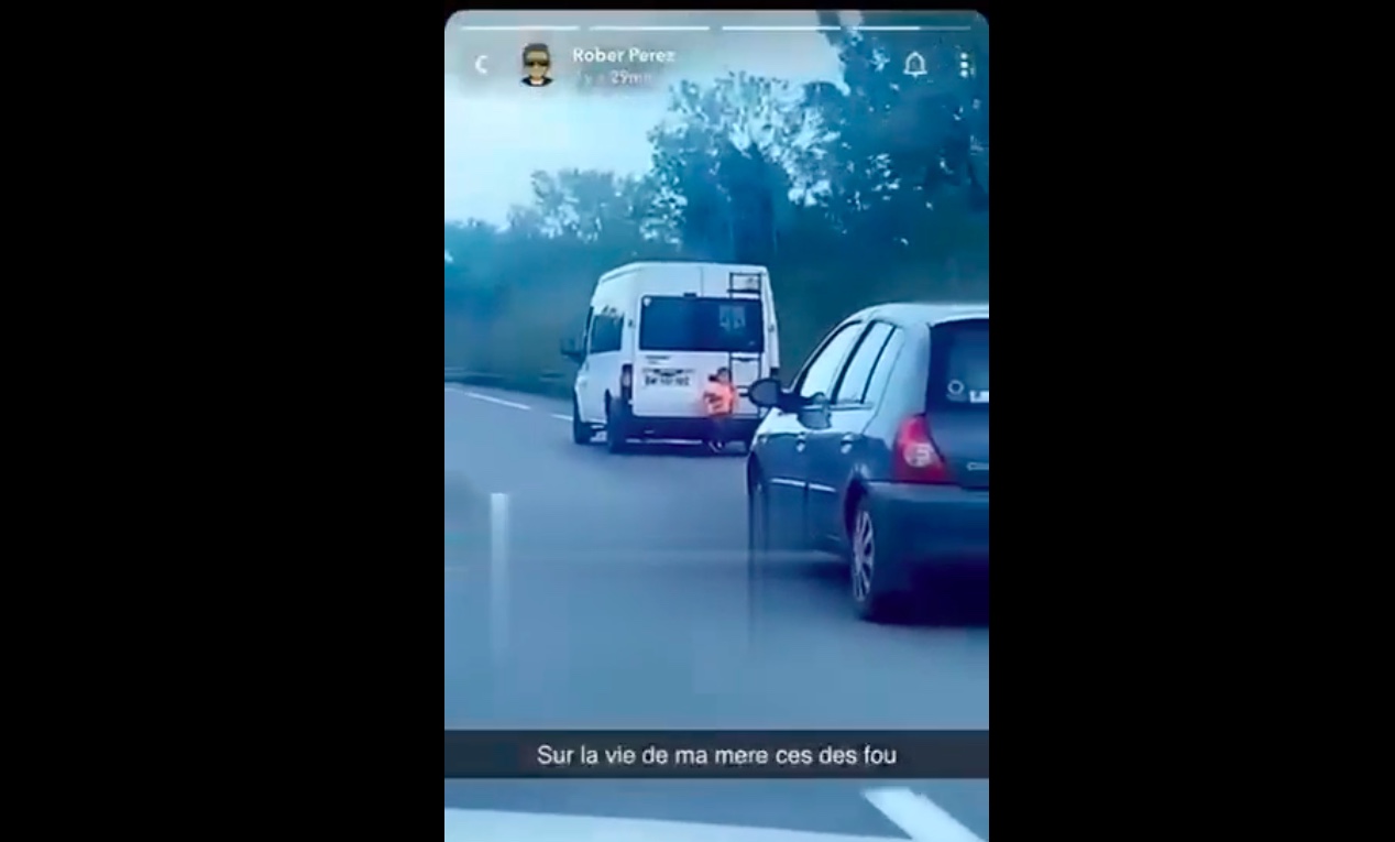 Un enfant accroché à l’arrière d’un Minibus sur l’autoroute